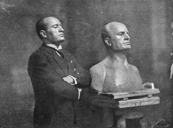 Benito Mussolini posing beside a bust of himself, 1926